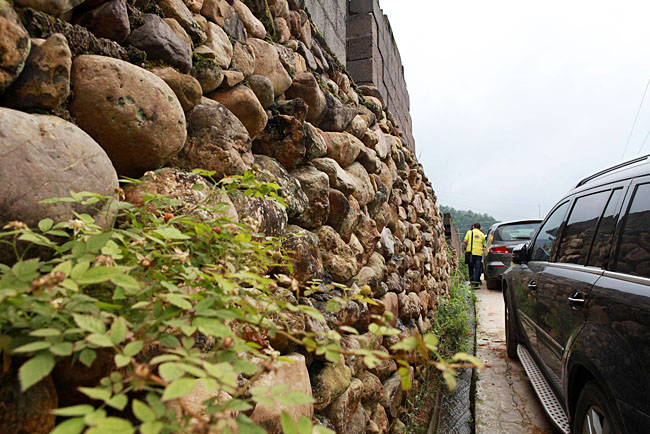 油石鄉(xiāng)梅嶺小學(xué)路口較窄，車隊(duì)只能停在路邊，步行上去